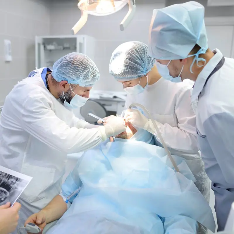 Dentists performing oral surgery in an operating room.
