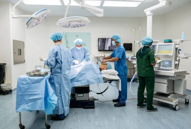 Surgical team operating in hospital room.