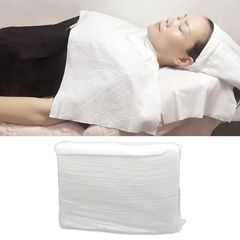 Spa blanket on relaxing person, folded towels below.
