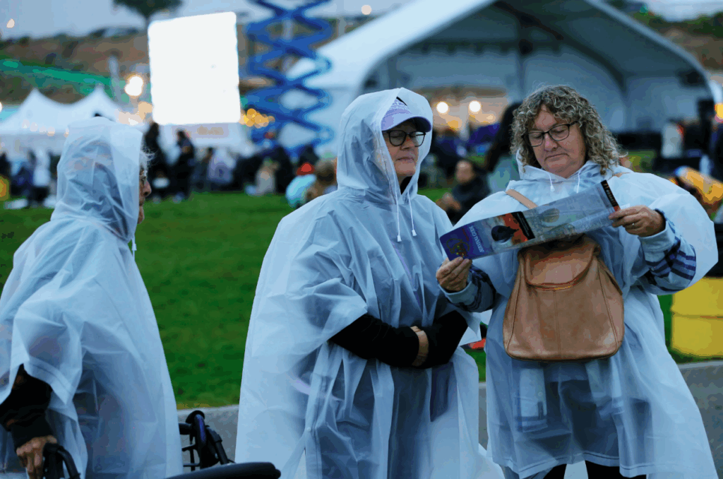 People wearing rain ponchos at outdoor event.
