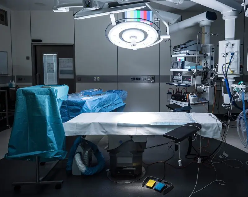Empty surgical room with operating table and equipment.
