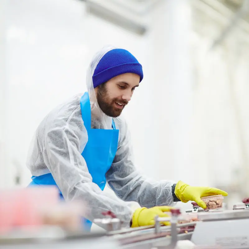 Worker packaging meat in a processing facility.