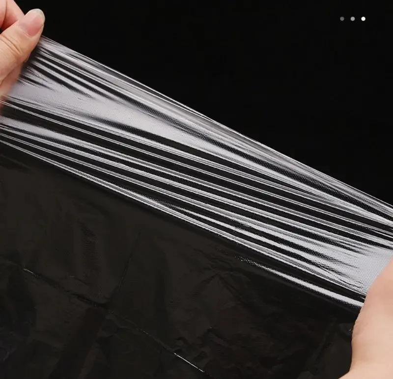 Hands stretching black biodegradable plastic wrap