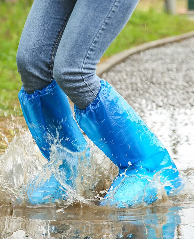 Person splashing in puddle with blue waterproof boots.