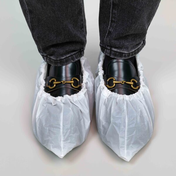 Shoes with protective plastic covers on hardwood floor.