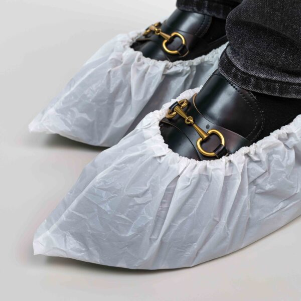 Shoes covered with white protective boot covers.