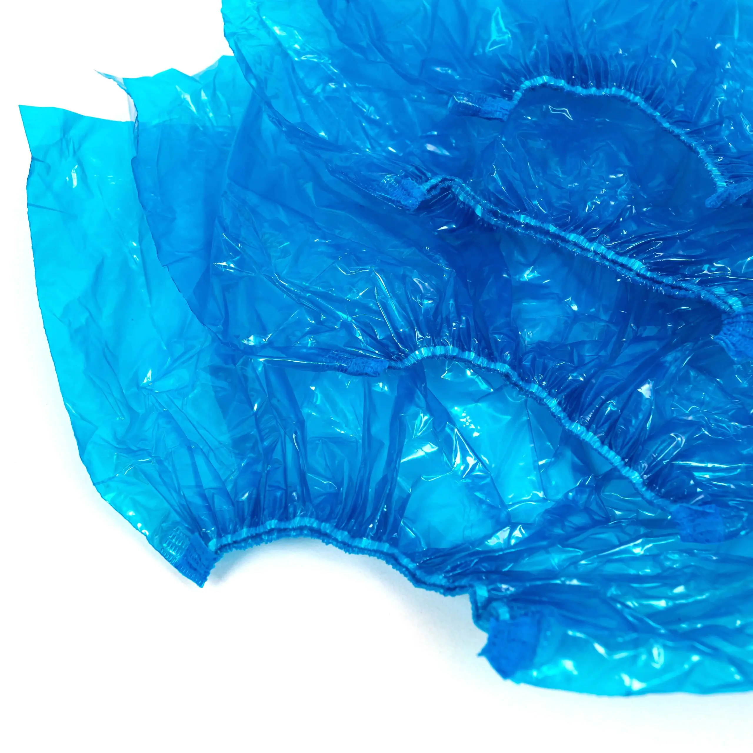 Blue disposable shoe covers on white surface