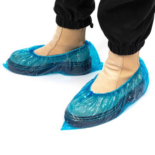 Feet with blue disposable shoe covers.