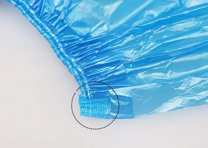 Close-up of blue plastic bag corner seam.