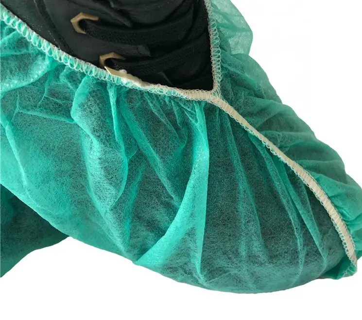 Green disposable shoe cover on black shoe