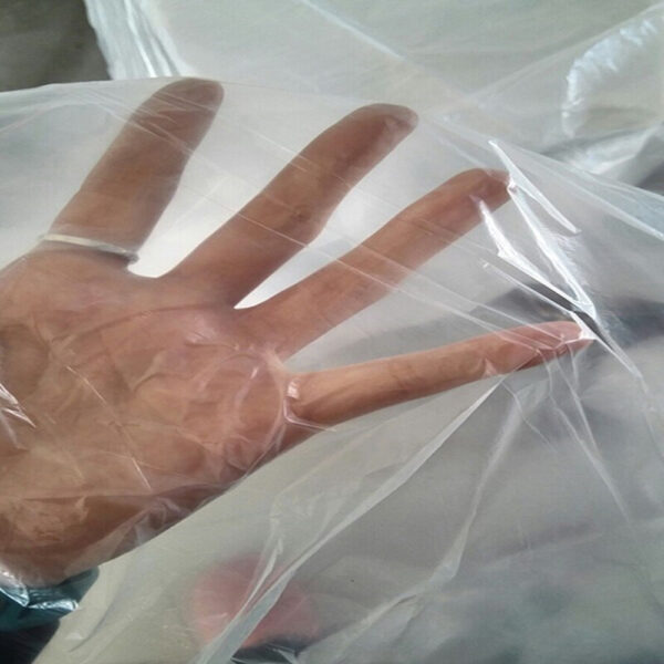 Hand stretching clear plastic sheet.