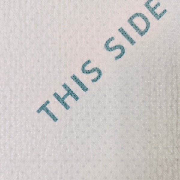 Close-up of fabric with text 'THIS SIDE'.