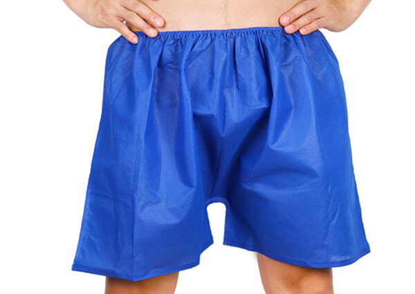 Person wearing blue disposable shorts.