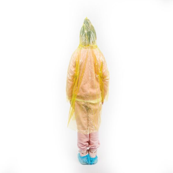 Child wearing yellow rain poncho standing indoors.