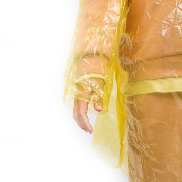 Person wearing yellow transparent raincoat close-up.