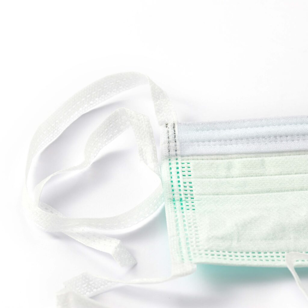 Close-up of disposable face mask on white background.