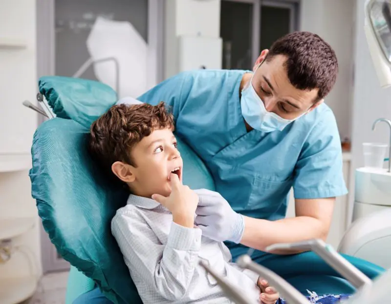 Dentist examining child's teeth in clinic