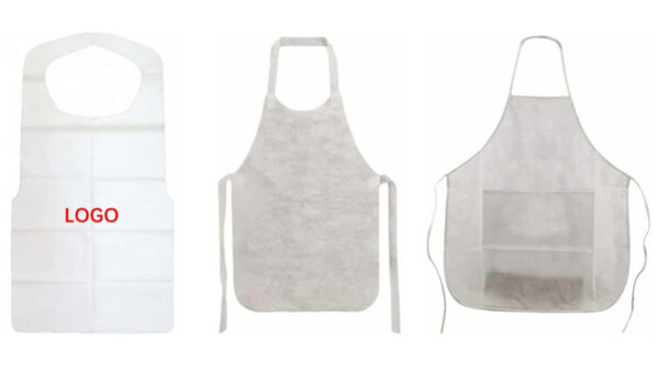 Three white disposable aprons displayed on a wall.