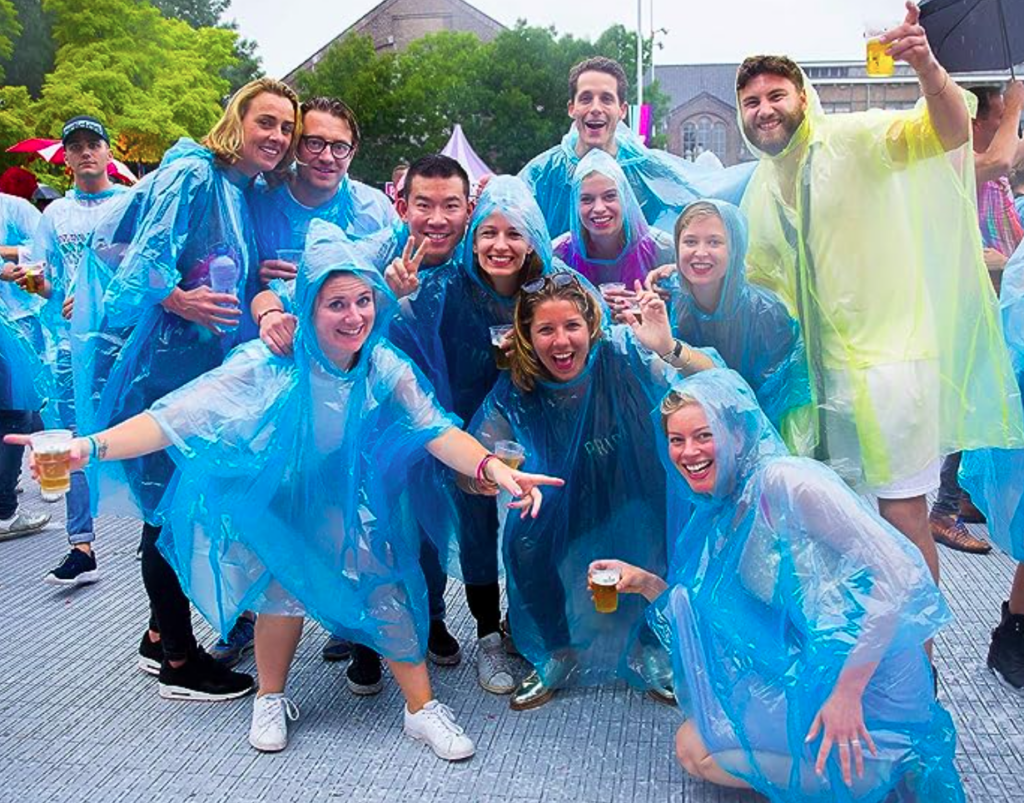 Group of friends in ponchos at outdoor festival.