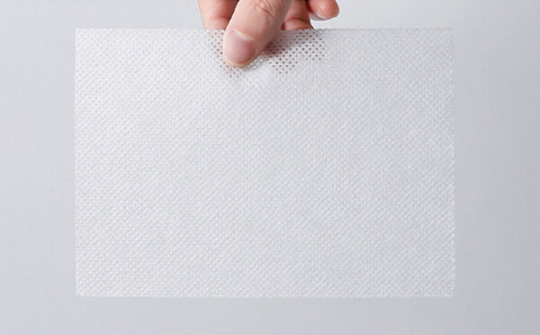 Person holding perforated plastic sheet.