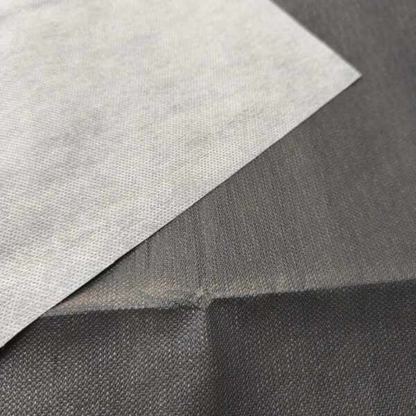 White fabric sheet on black background close-up.