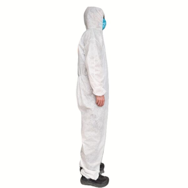 Person in protective coverall and mask, side view